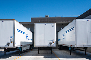 積み降ろしのために倉庫に駐車されたセミトラックトレーラー。