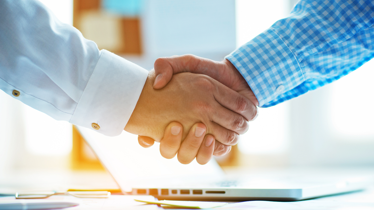  Businessmen shaking hands in an office.