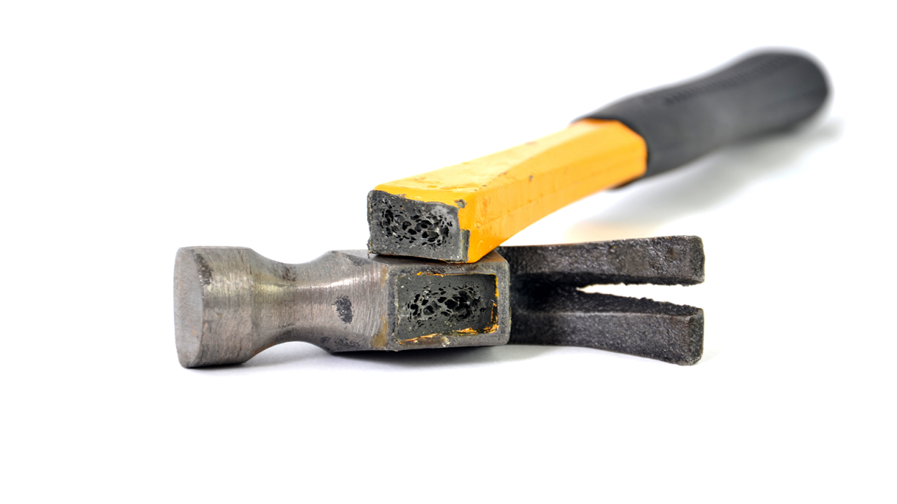 Un martillo roto con mango amarillo y agarre negro